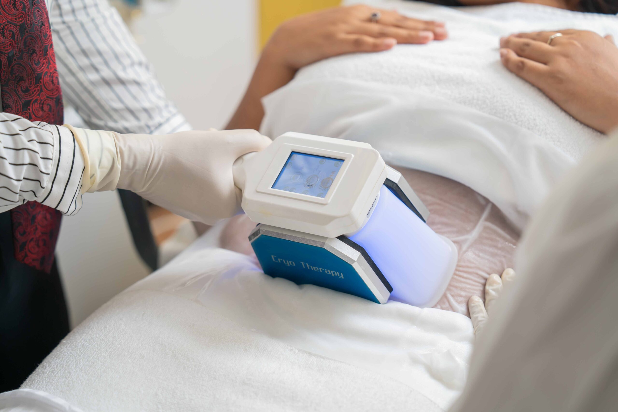 Fat freezing treatment at Mackcare Skin Clinic. Client experiencing non-invasive fat reduction with applicator and cooling technology.